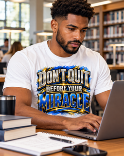 Man sitting at computer wearing a white t-shirt.