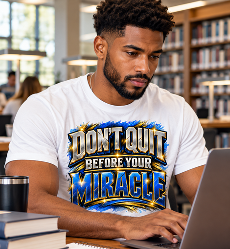 Man sitting at computer wearing a white t-shirt.