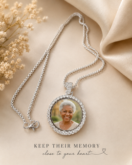 Silver necklace with a photo pendant on a beige fabric background