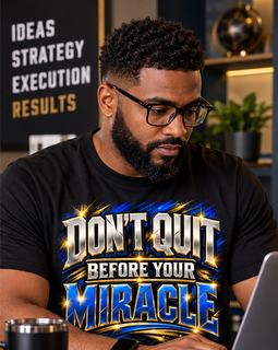 Man sitting at computer wearing a black t-shirt.